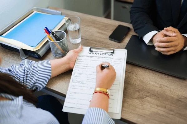 woman completing visa application form 600nw 2695517443